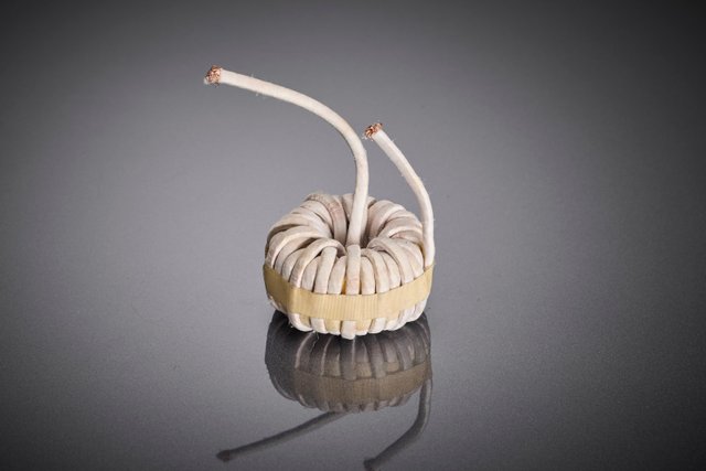 The toroidal core choke shows the implementation of the optimized litz wire solution in the real OBC component and illustrates the contribution of the winding to increased efficiency and thermal stability of modern AC/DC on-board chargers.