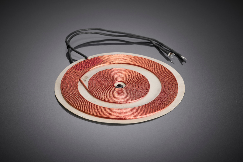 The flat pancake coil shows the result of a material- and process-optimized litz wire design for inductive cooking systems with high thermal requirements.